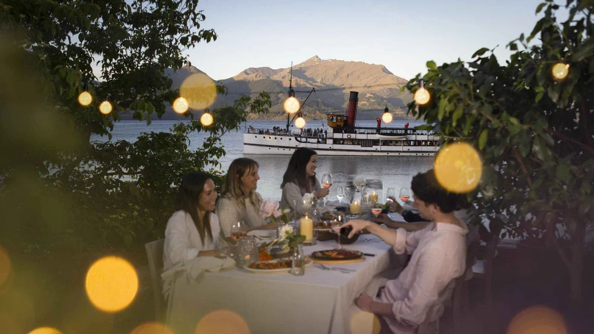 A BBQ table set on the lawn at Walter Peak High Country Farm — TSS Earnslaw Lake Wakatipu cruise, Queenstown, New Zealand