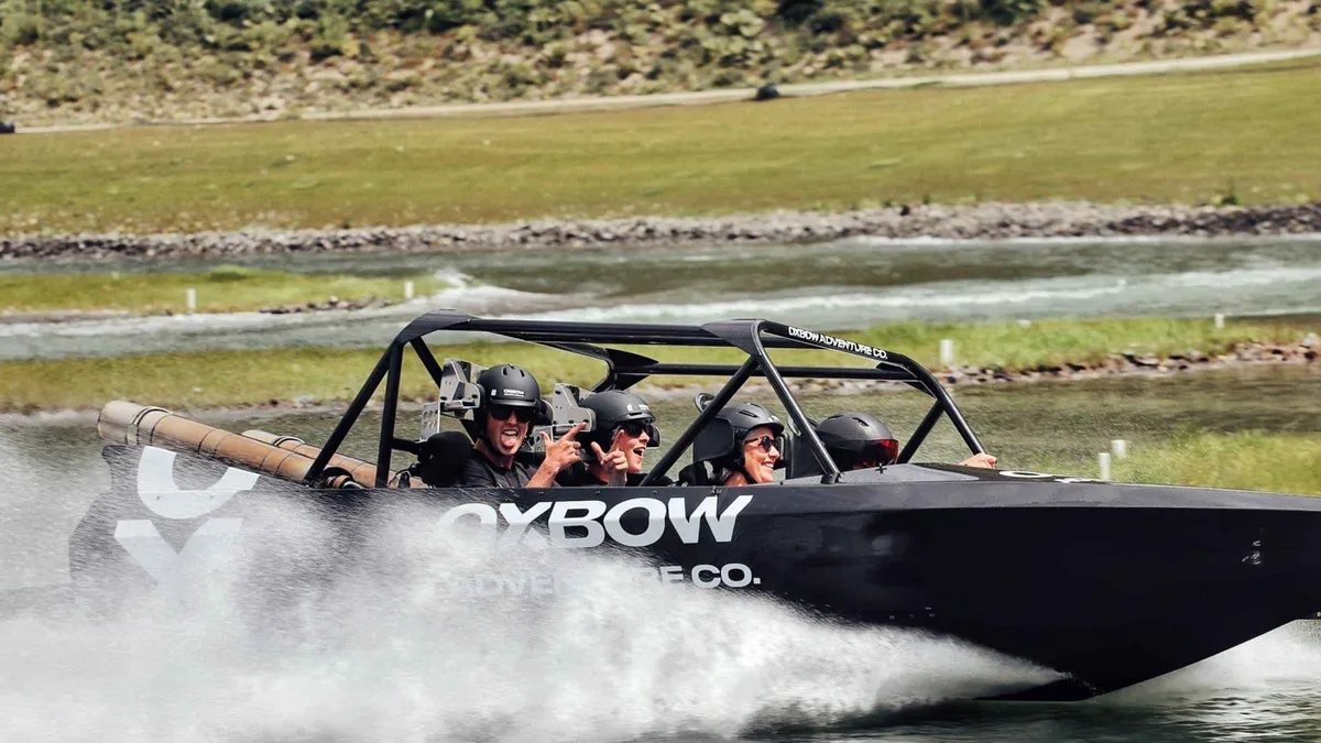 A jet sprint boat cornering hard on a tight water course — Queenstown adventure activities, New Zealand
