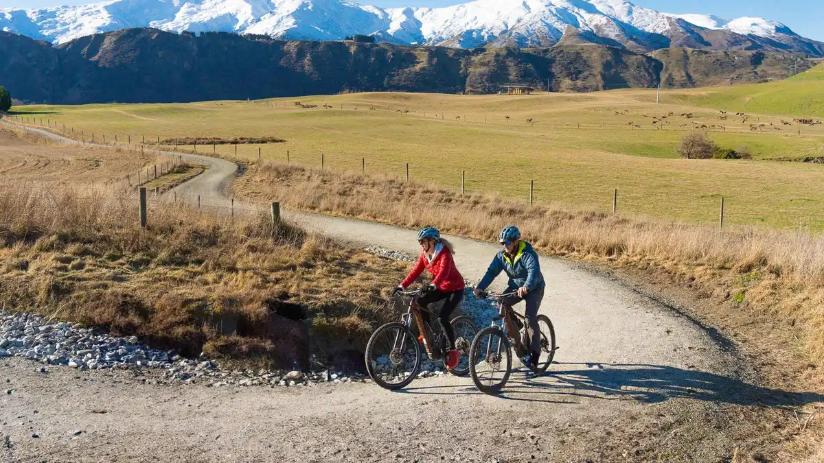 A cyclist crossing a river bridge on the trail from Arrowtown — Arrowtown from Queenstown, New Zealand