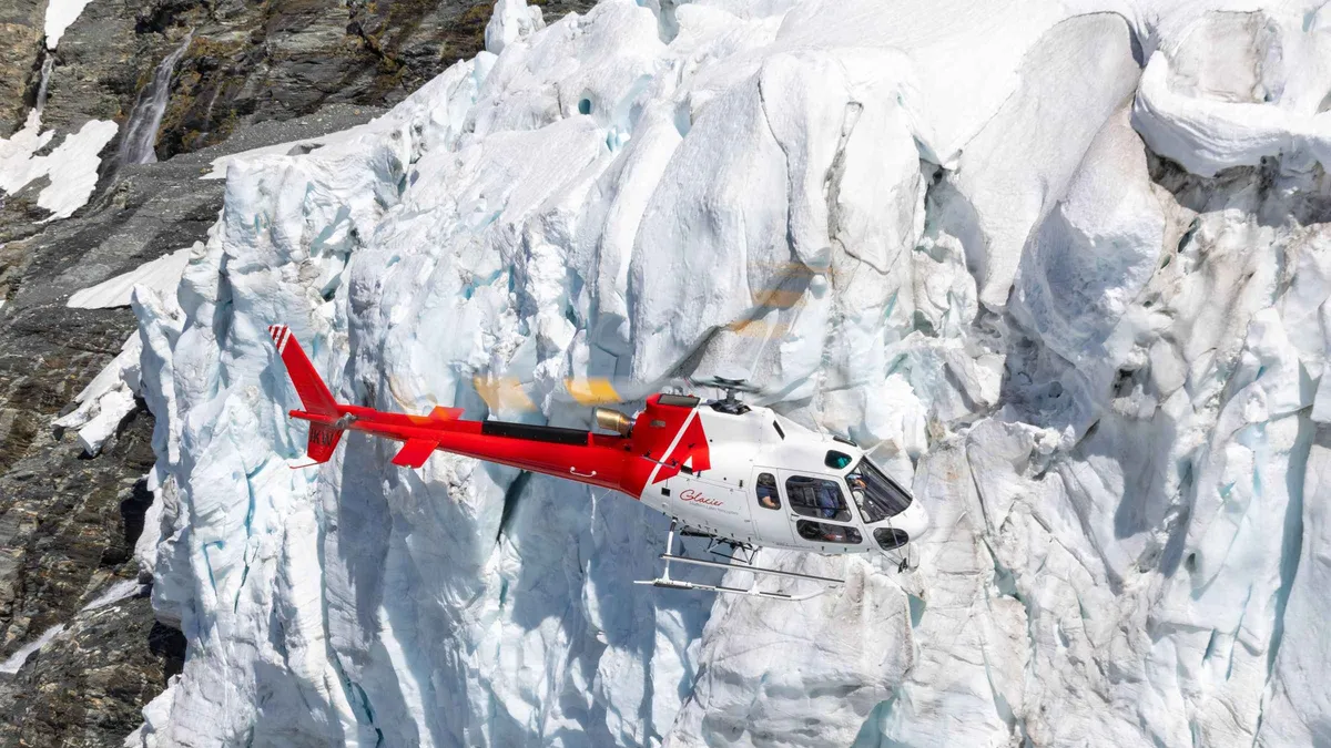 A helicopter on snow beside a glacier in Mount Aspiring National Park — Queenstown tours, New Zealand