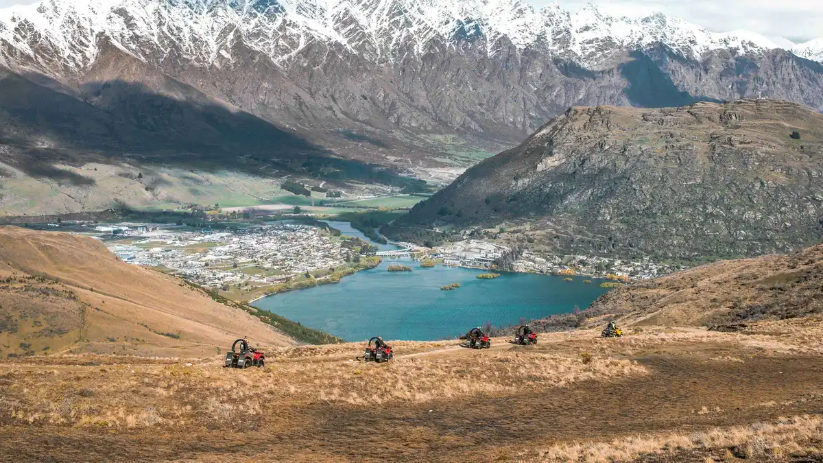 Quad bikes on a farm track high above the Wakatipu Basin — Queenstown adventure activities, New Zealand