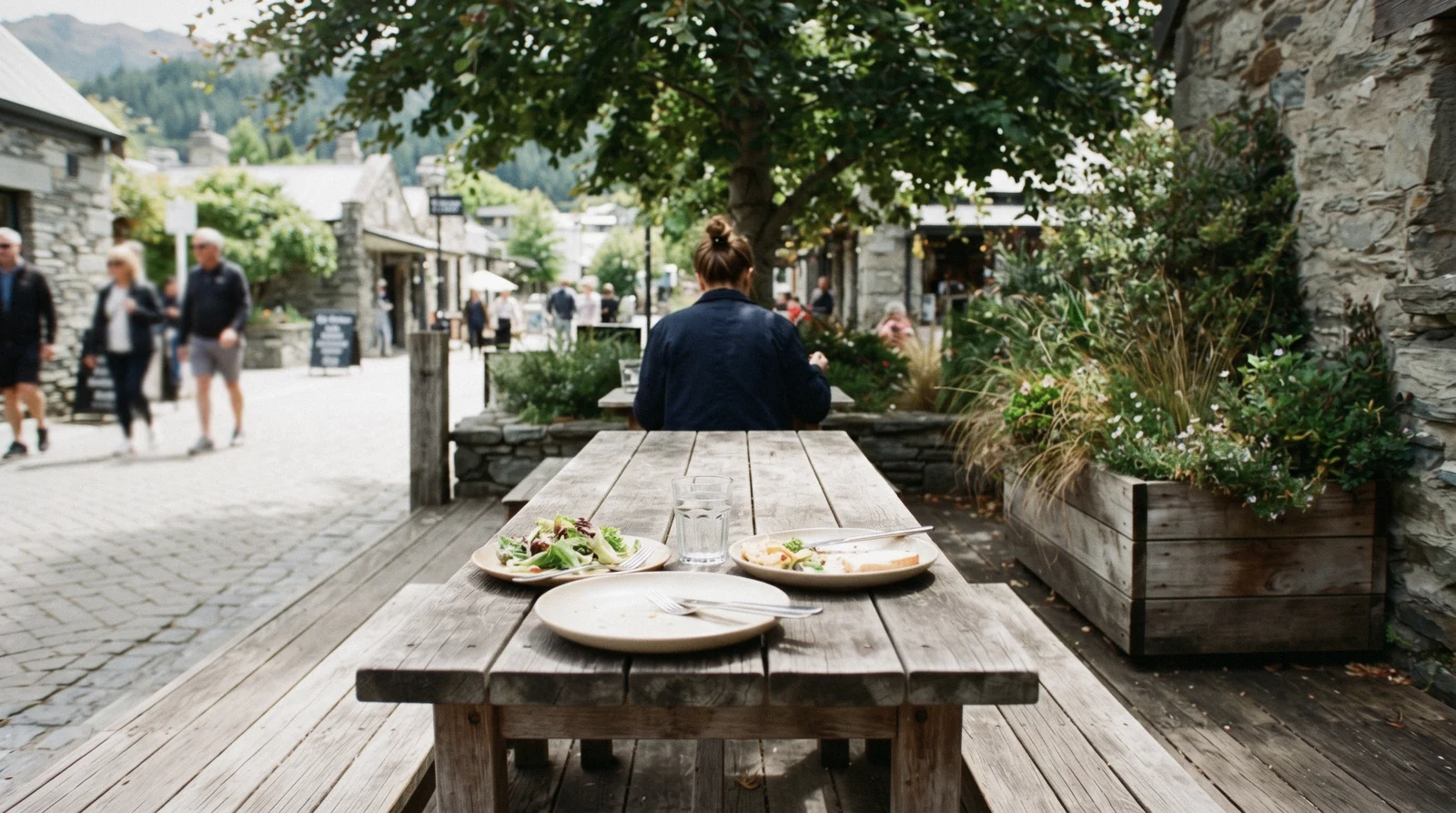 An evening table on a lakefront terrace with the Remarkables behind it, at one of the restaurants in Queenstown, New Zealand